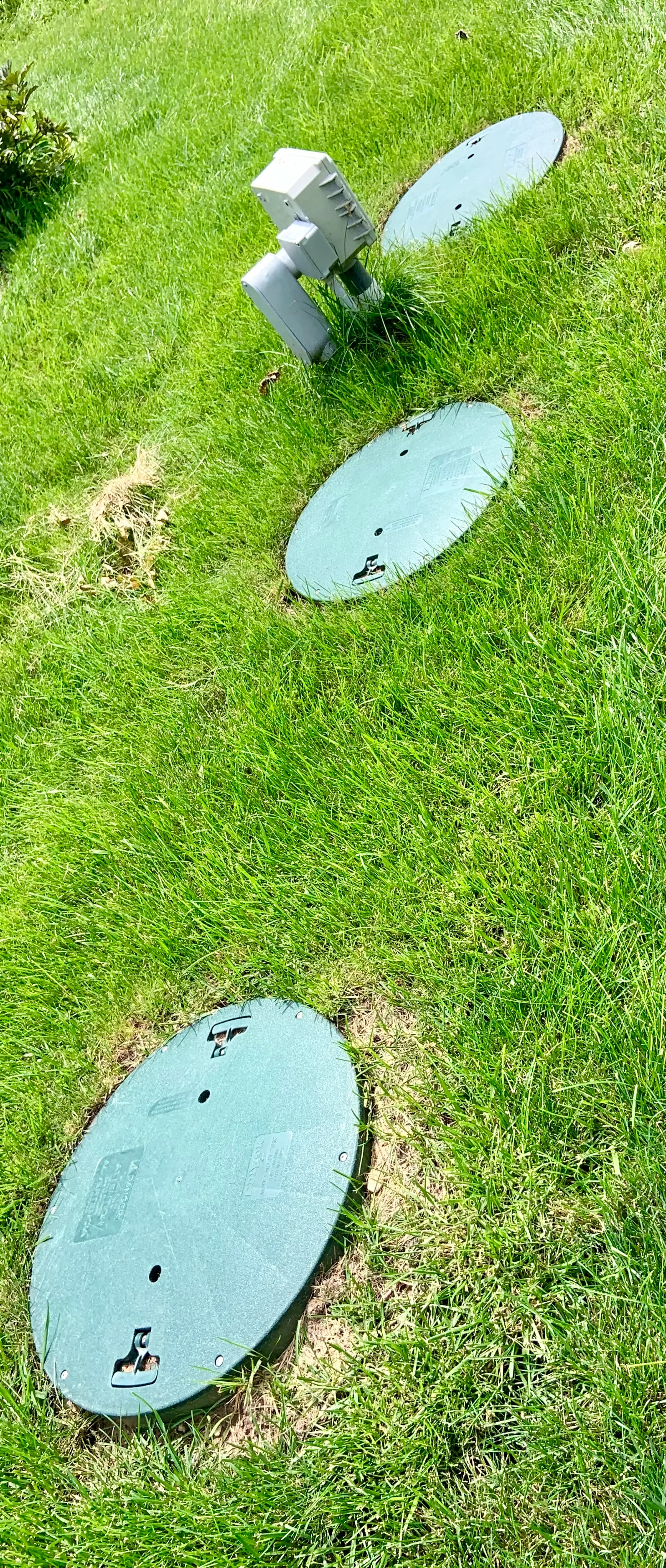 Technician inspecting an open septic tank during a home-sale inspection in Western North Carolina