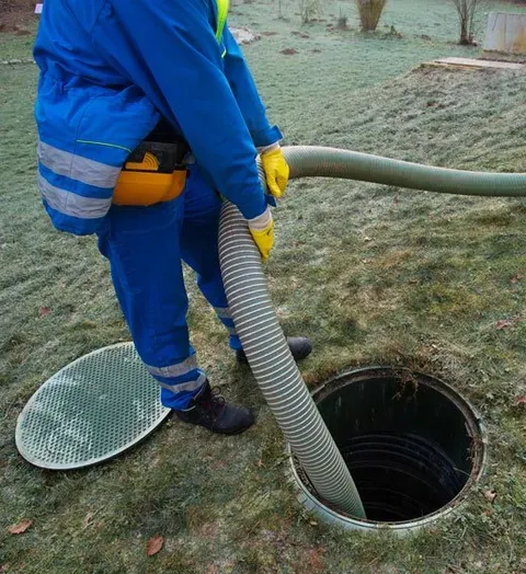 Technician cleaning an open septic tank at a Western North Carolina property